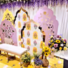 A cute haldi-mehendi chair amidst flowers and props.