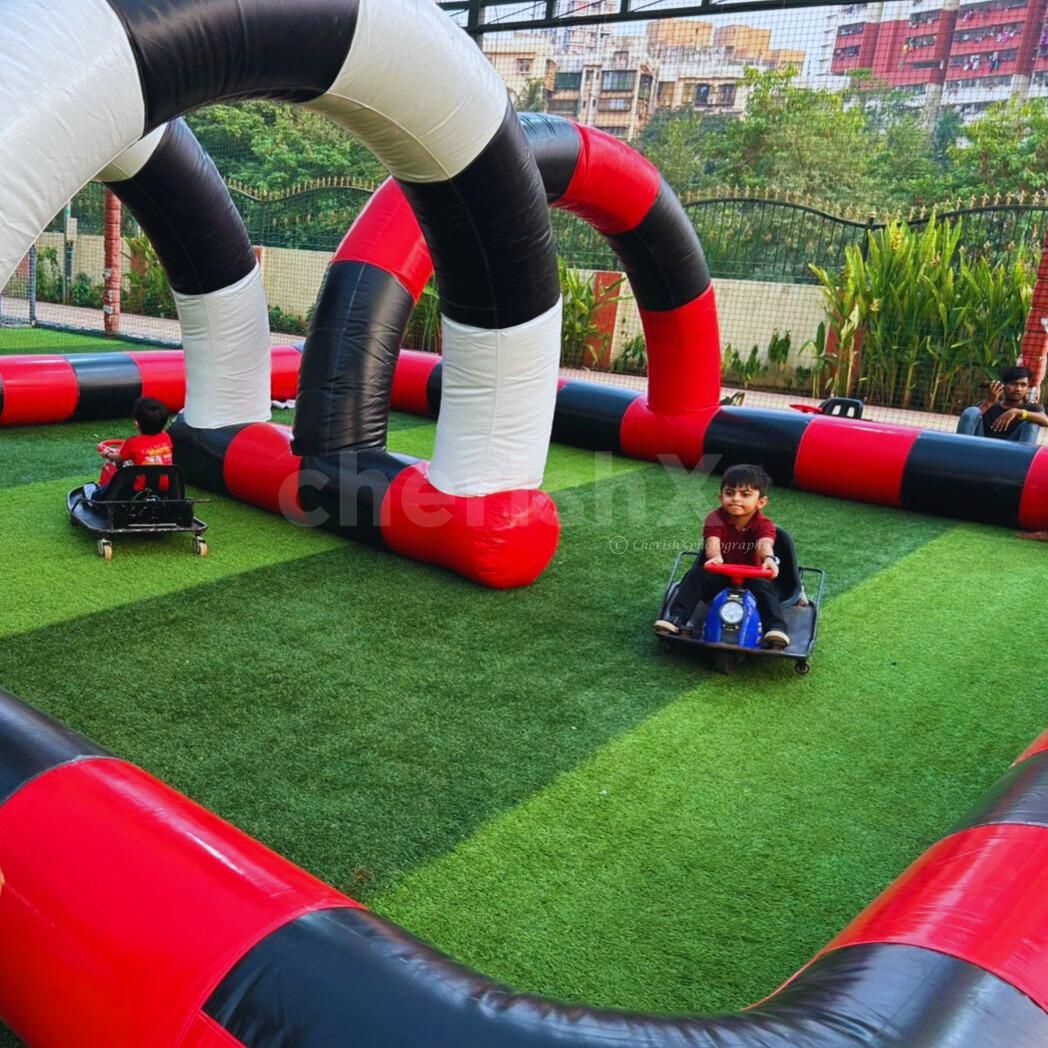 Kids Go-karting setup with inflatable colorful boundaries forms vibrant racetrack