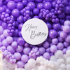 Stylish birthday setup with purple and white balloons wall and sparkling LED digital.