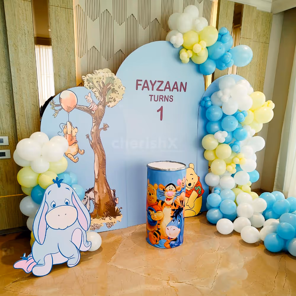 Pastel yellow, blue, and white balloon arch for soft light.
