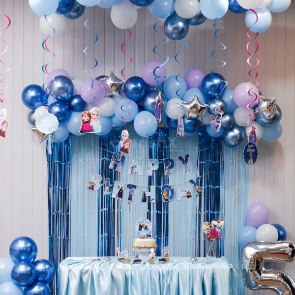 Frozen cake toppers and balloon clusters complete the joyful celebration look