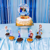 Frozen cake toppers and balloon clusters complete the joyful celebration look