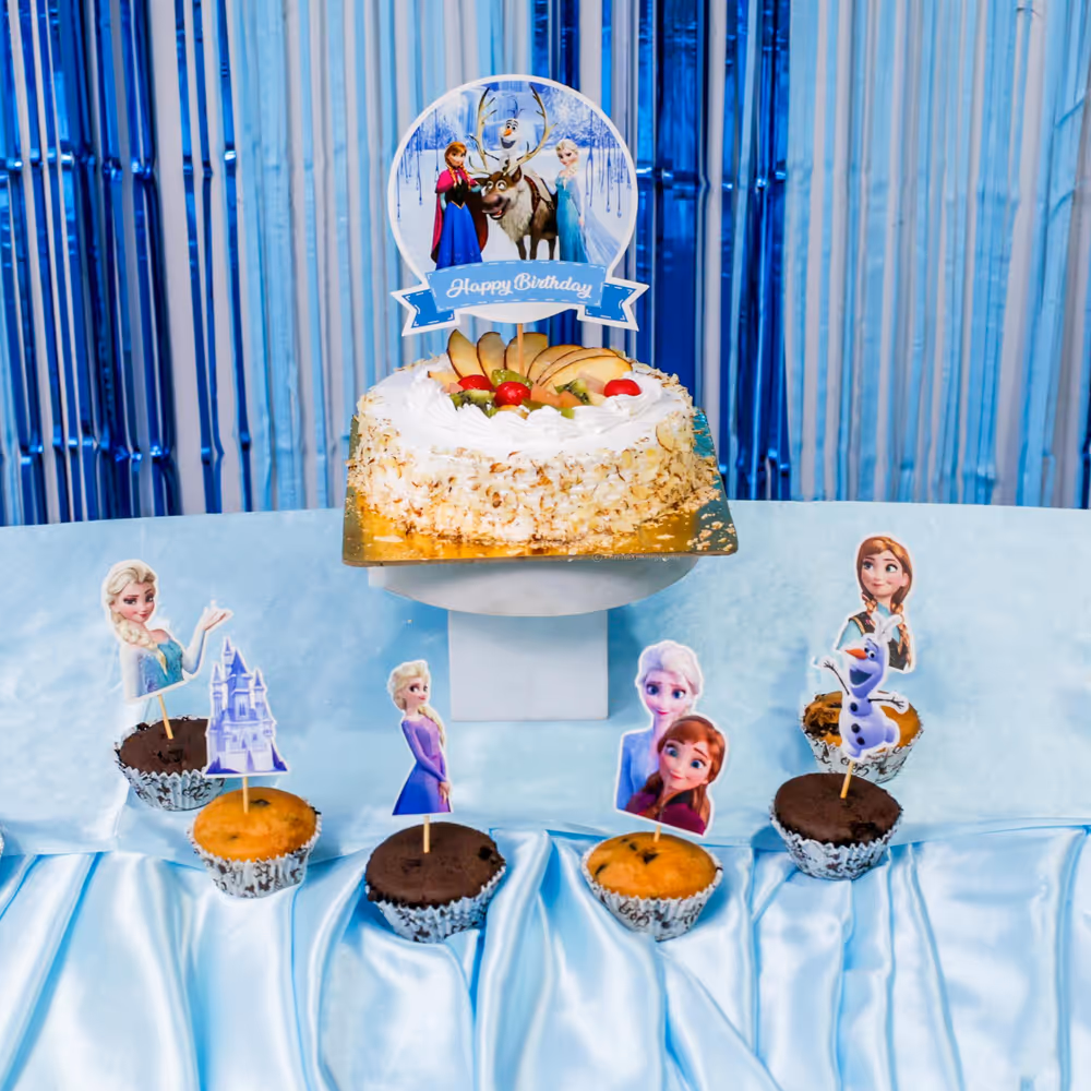 Frozen cake toppers and balloon clusters complete the joyful celebration look