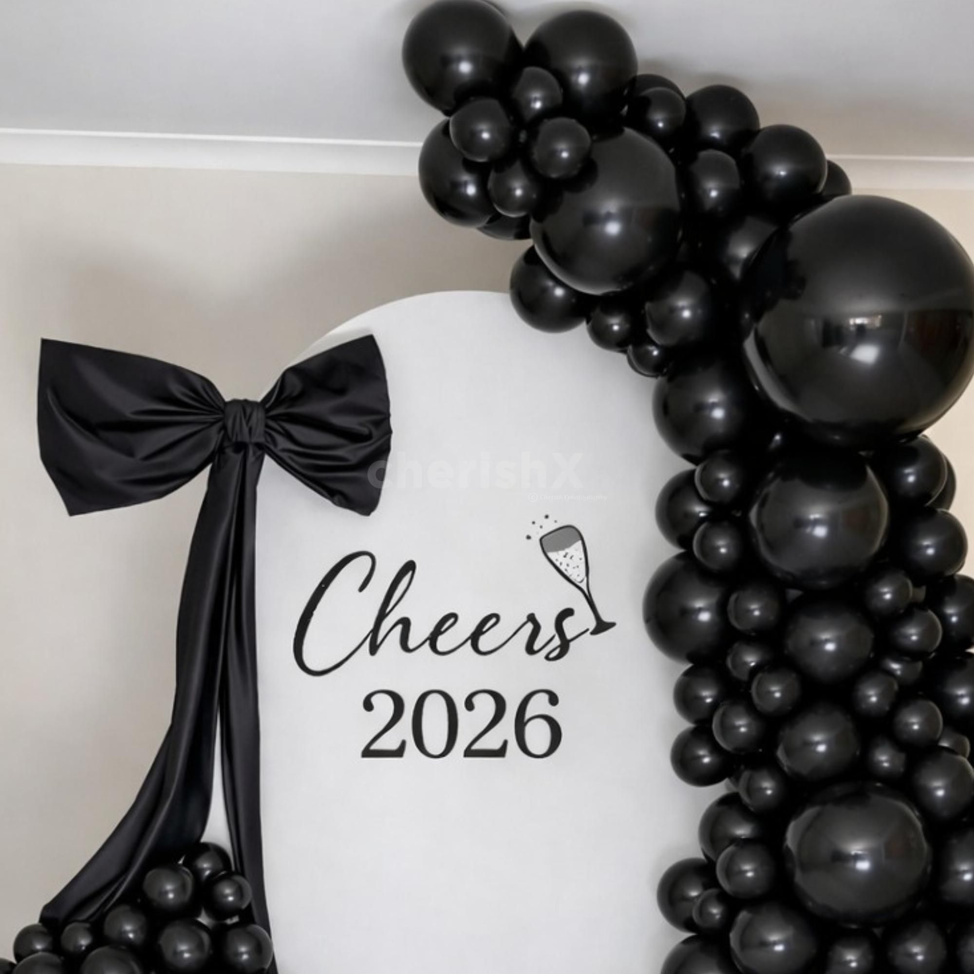 Metallic black balloon arch creates a deep and eye-catching backdrop for the celebration.