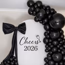 Metallic black balloon arch creates a deep and eye-catching backdrop for the celebration.