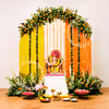 Fairy lights twinkle on marigold backdrop hanging from the circular stand for ganpati decor
