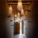 Floating white ghosts and fairy lights create a spooky, magical ceiling display.