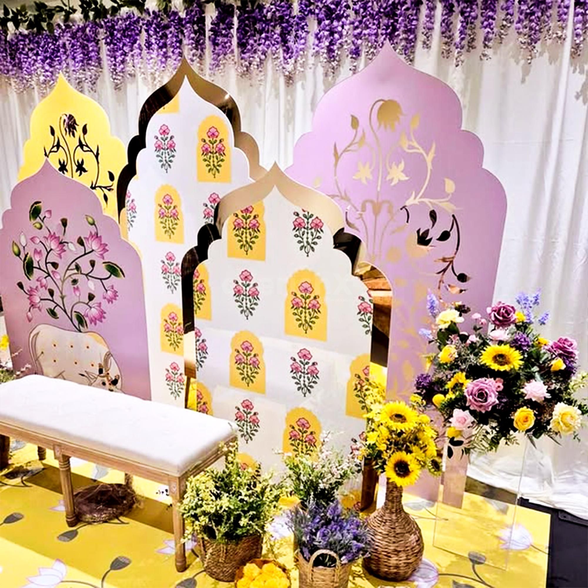 A cute haldi-mehendi chair amidst flowers and props.
