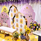 A cute haldi-mehendi chair amidst flowers and props.