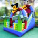 The inflatable playground is bright with green, blue, and yellow colors.