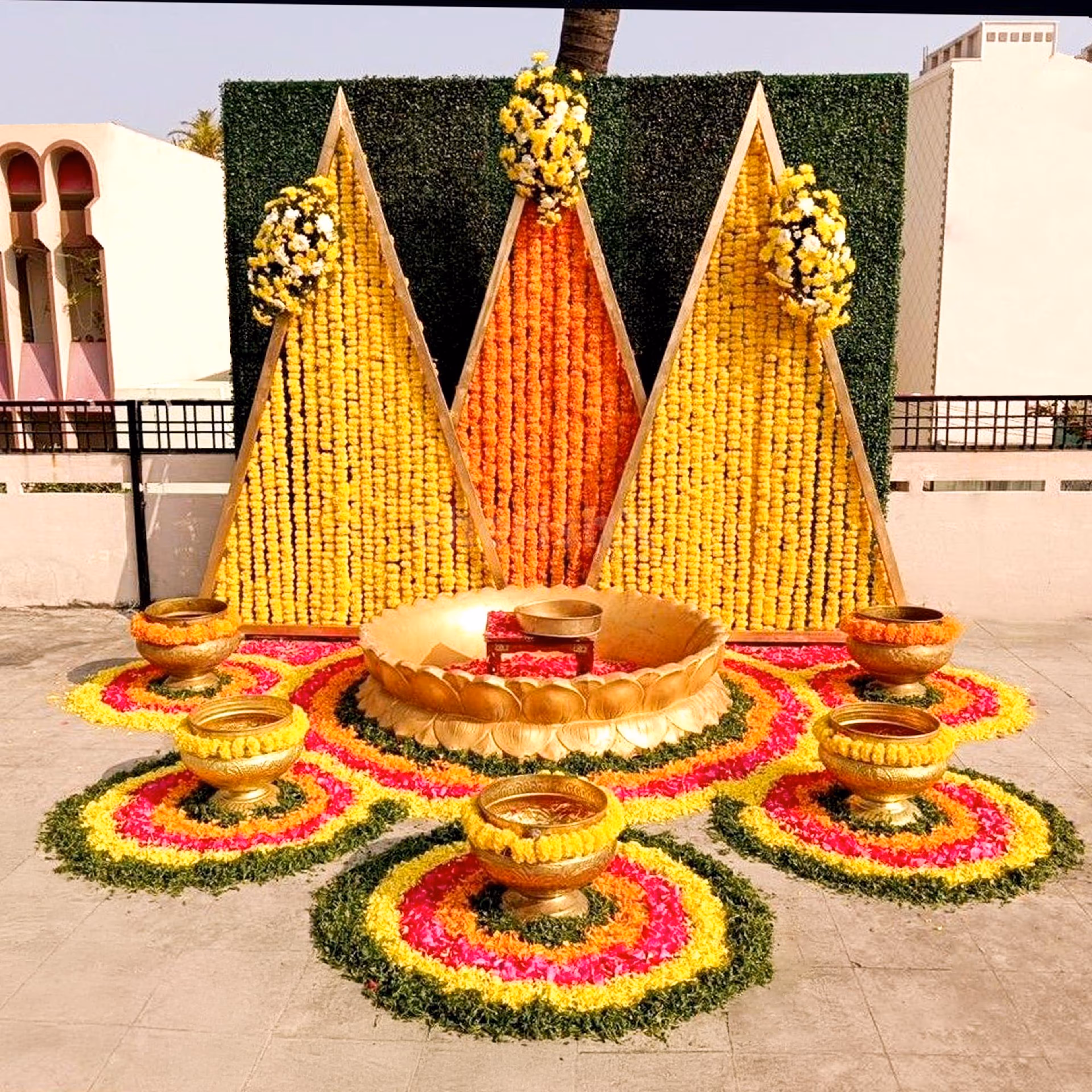 Floral triangle backdrop emitting haldi & mehendi magic.