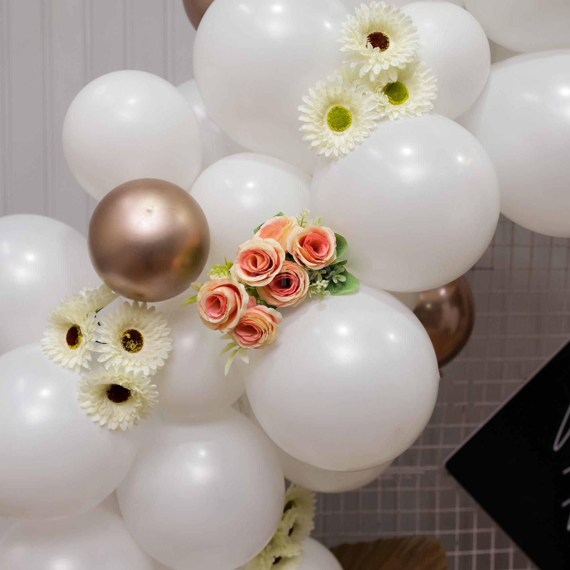 White and Champagne balloons with artificial flowers set up ideal for Bday