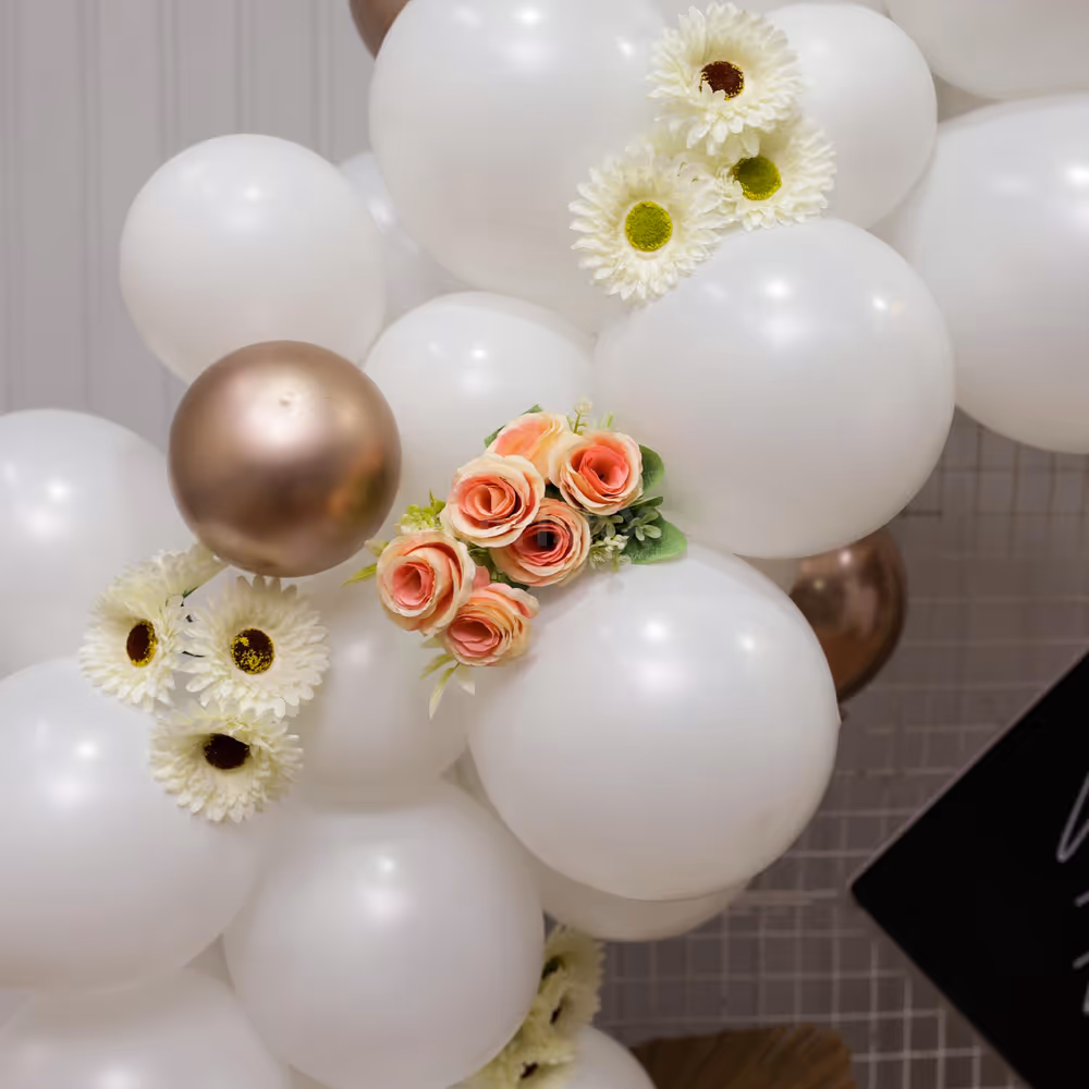 White and Champagne balloons with artificial flowers set up ideal for Bday