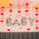Free-flying and anchored balloons add a whimsical touch to the bed and floor.