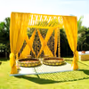Regal yellow mandap stands covered in soft floral garlands.