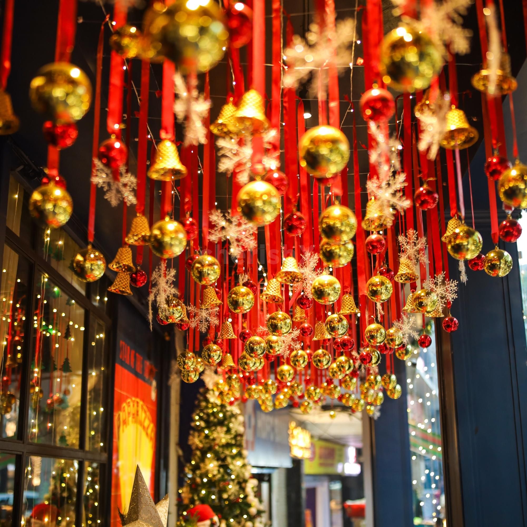 Red and gold balls hanging with red ribbons dangle beautifully with warm white fairy glow