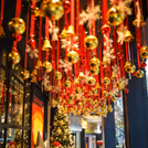 Red and gold balls hanging with red ribbons dangle beautifully with warm white fairy glow