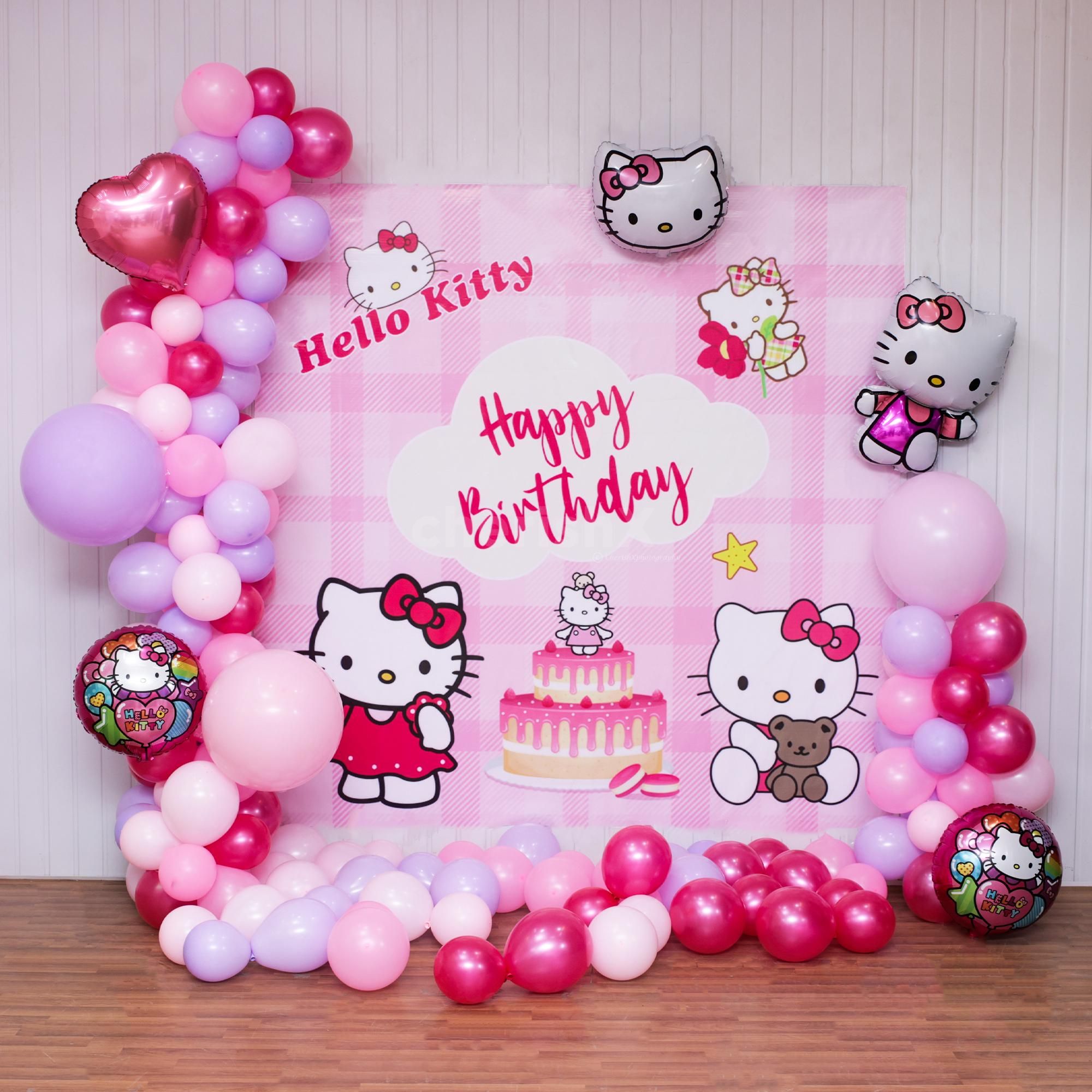 A colorful pastel balloon arch surrounds the Hello Kitty backdrop.