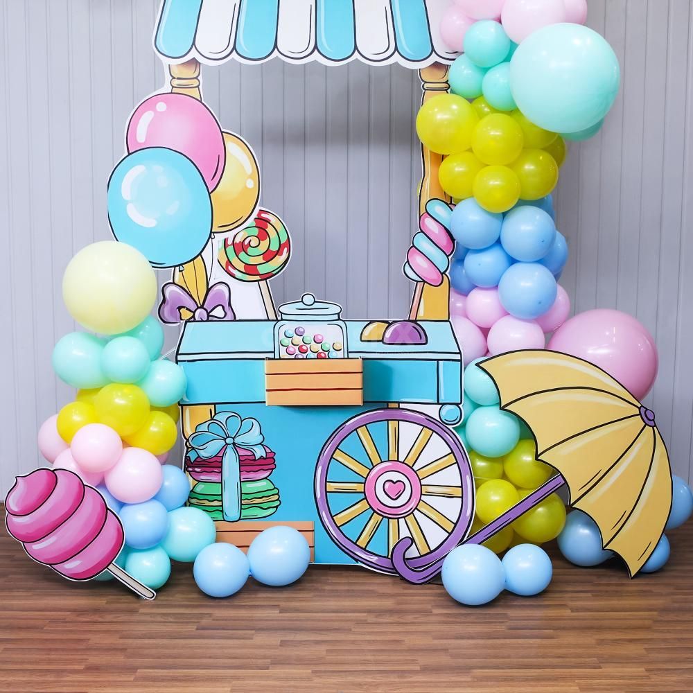 Pastel balloons and candy cutouts provide a sweet and playful atmosphere.