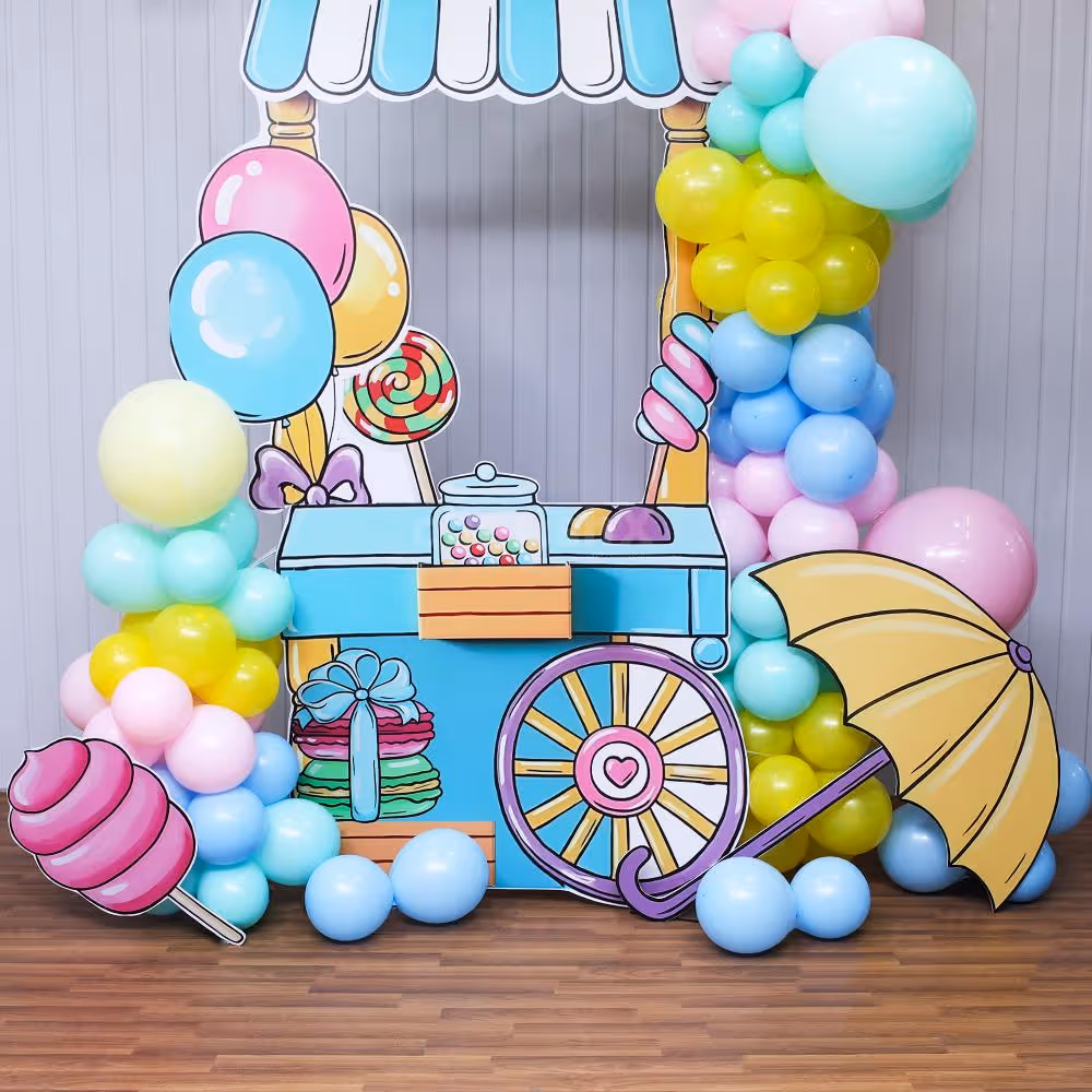Pastel balloons and candy cutouts provide a sweet and playful atmosphere.