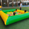 A spacious inflatable soft-walled ball pit, filled with hundreds of colourful balls