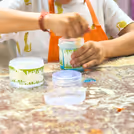 Kids mixing magic colours into slime bowls