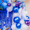 Ceiling balloon bunches and foil stars swirl with balloon arch for birthday magic