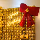 Multiple lighting, like neon B'day, floor lamps and LED candles, add to the warmth
