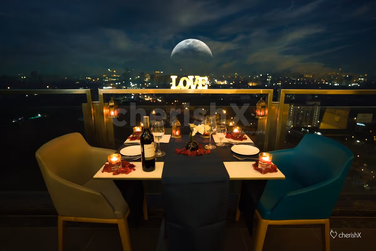 A Romantic Candle Light Dinner table decorated with Rose petals and candles.