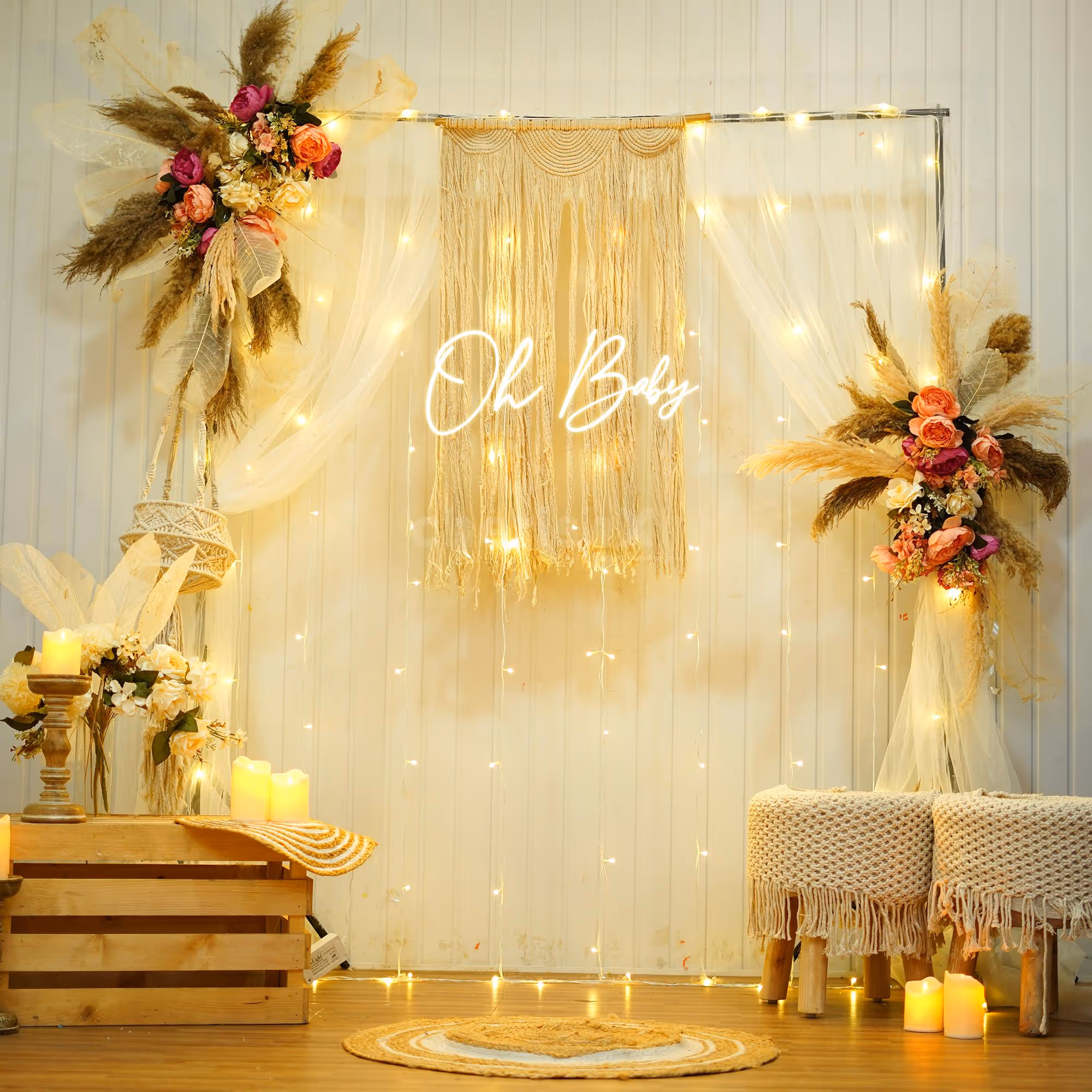 Pampas and boho drapery around a warm "Oh Baby" neon sign.