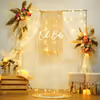 Pampas and boho drapery around a warm "Oh Baby" neon sign.