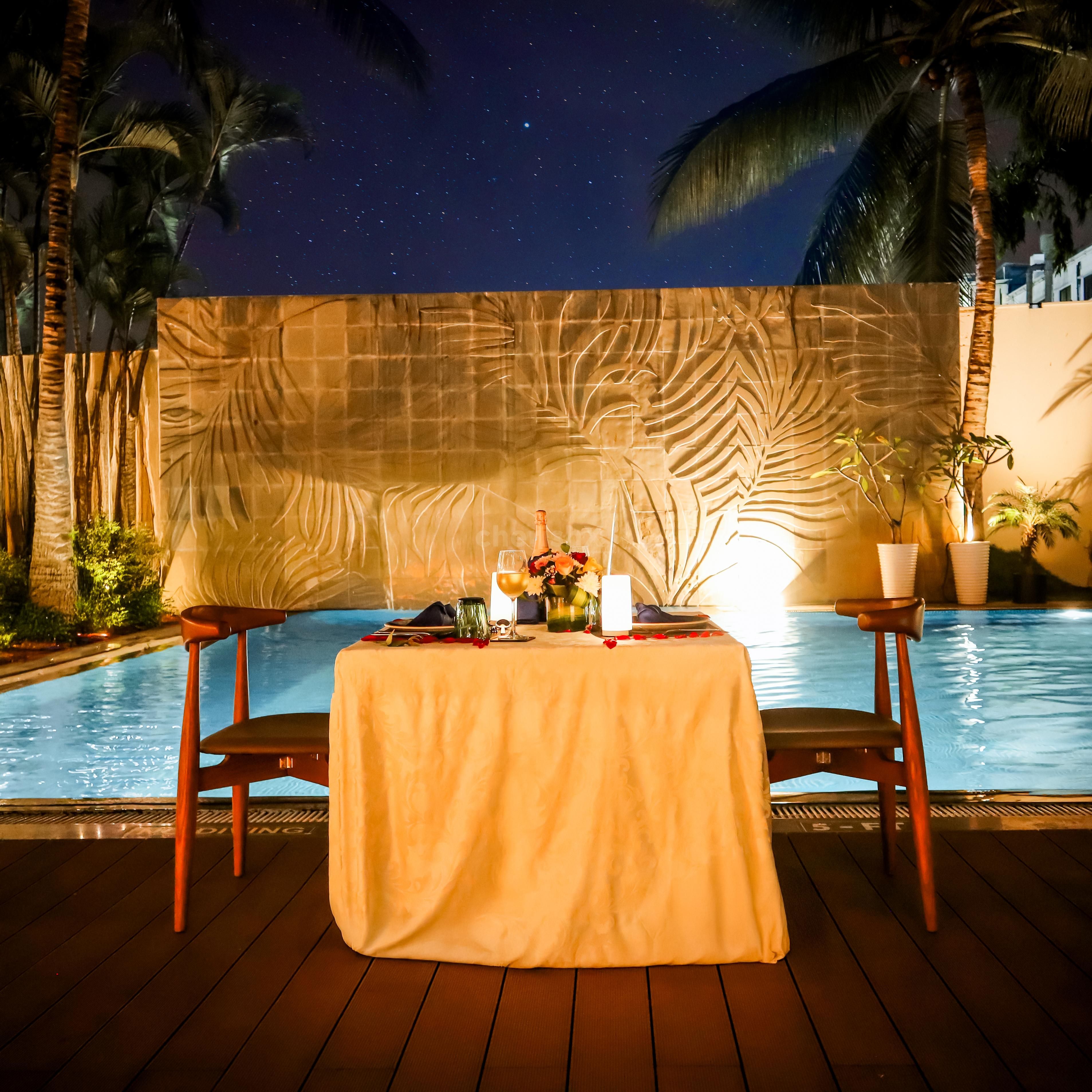 Private poolside proposal experience at Grand Mercure with beautifully decorated table, rose petals, candlelight, and luxury seating.