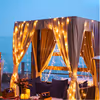 A private cabana adorned with stunning floral and balloon décor, illuminated with ambient lights