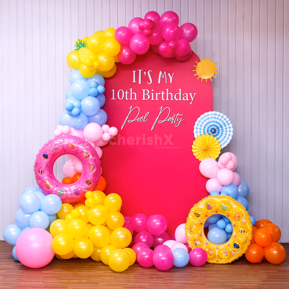 A colorful Pink Pool Party with bright balloons and inflatables