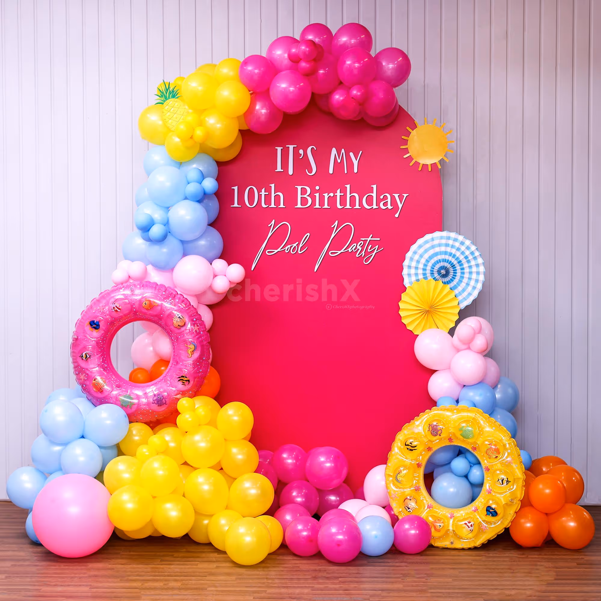 A colorful Pink Pool Party with bright balloons and inflatables