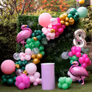 A green tropical backdrop and colorful balloons.