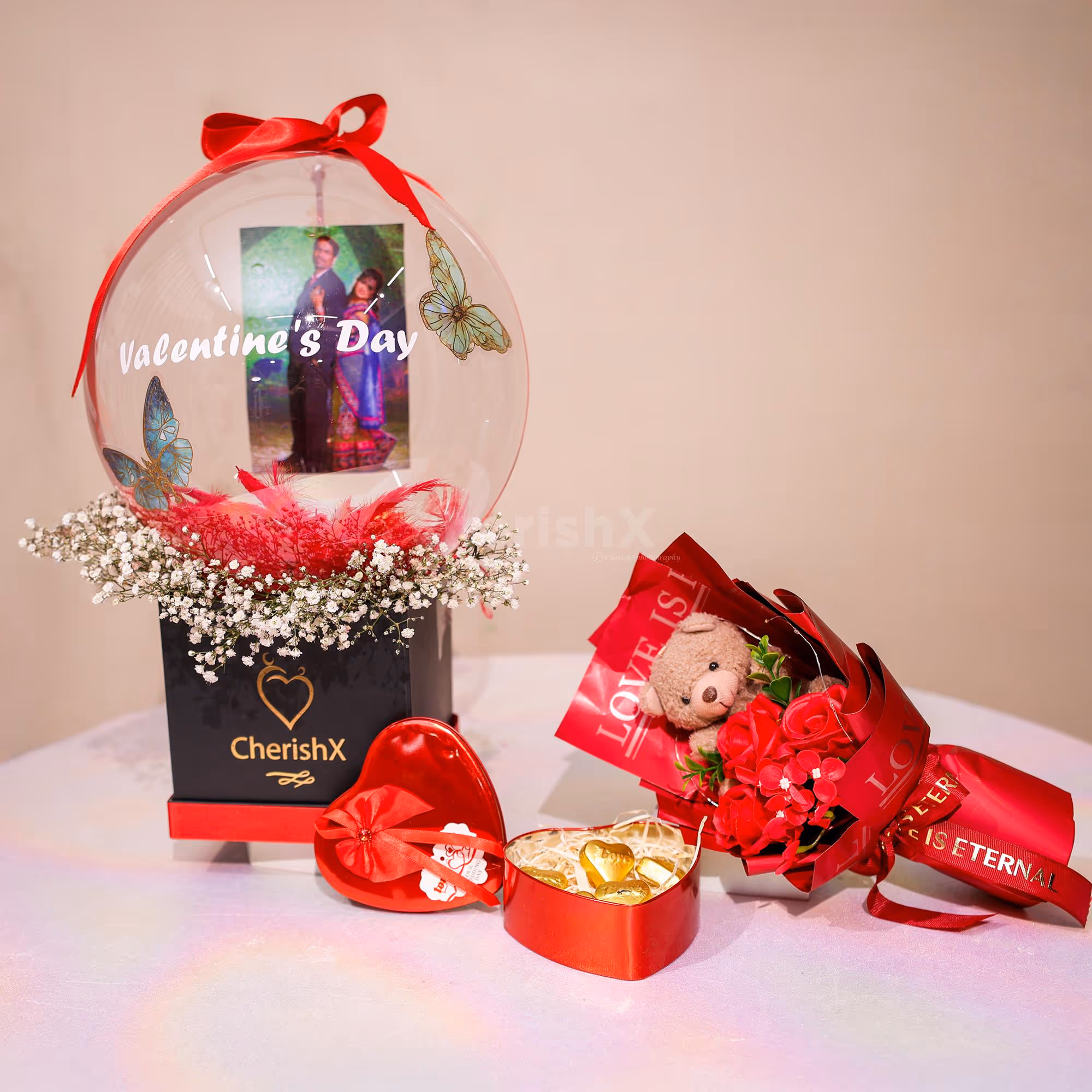 Soft baby breath bunches in the bucket against the bubble balloon are heart-warming