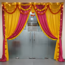 Bright drapes and tassels frame a festive welcome zone.
