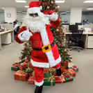 Santa is greeting guests and distributing gifts with holiday cheer.