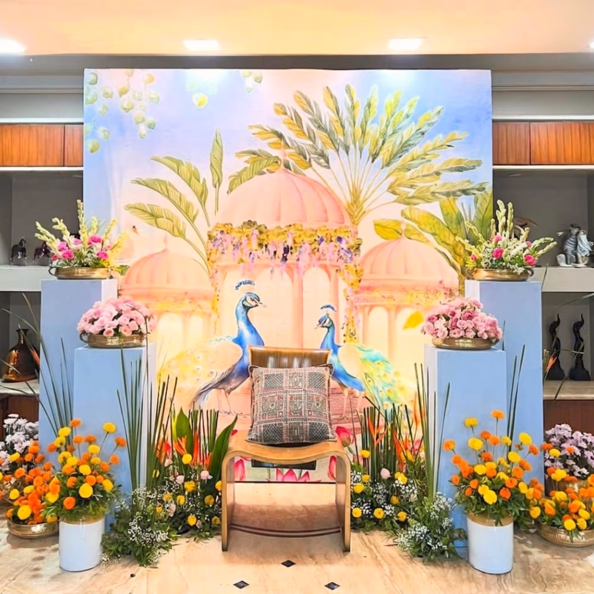 Baby Shower Decorations Include Blue Pedestal Tables With Brass Pots With Flowers.