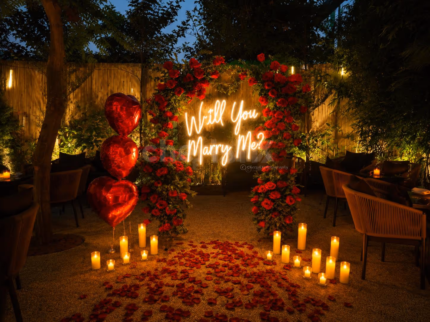 Romantic alfresco proposal dinner setup with candlelight décor, rose petals, and elegant open-air dining for couples.