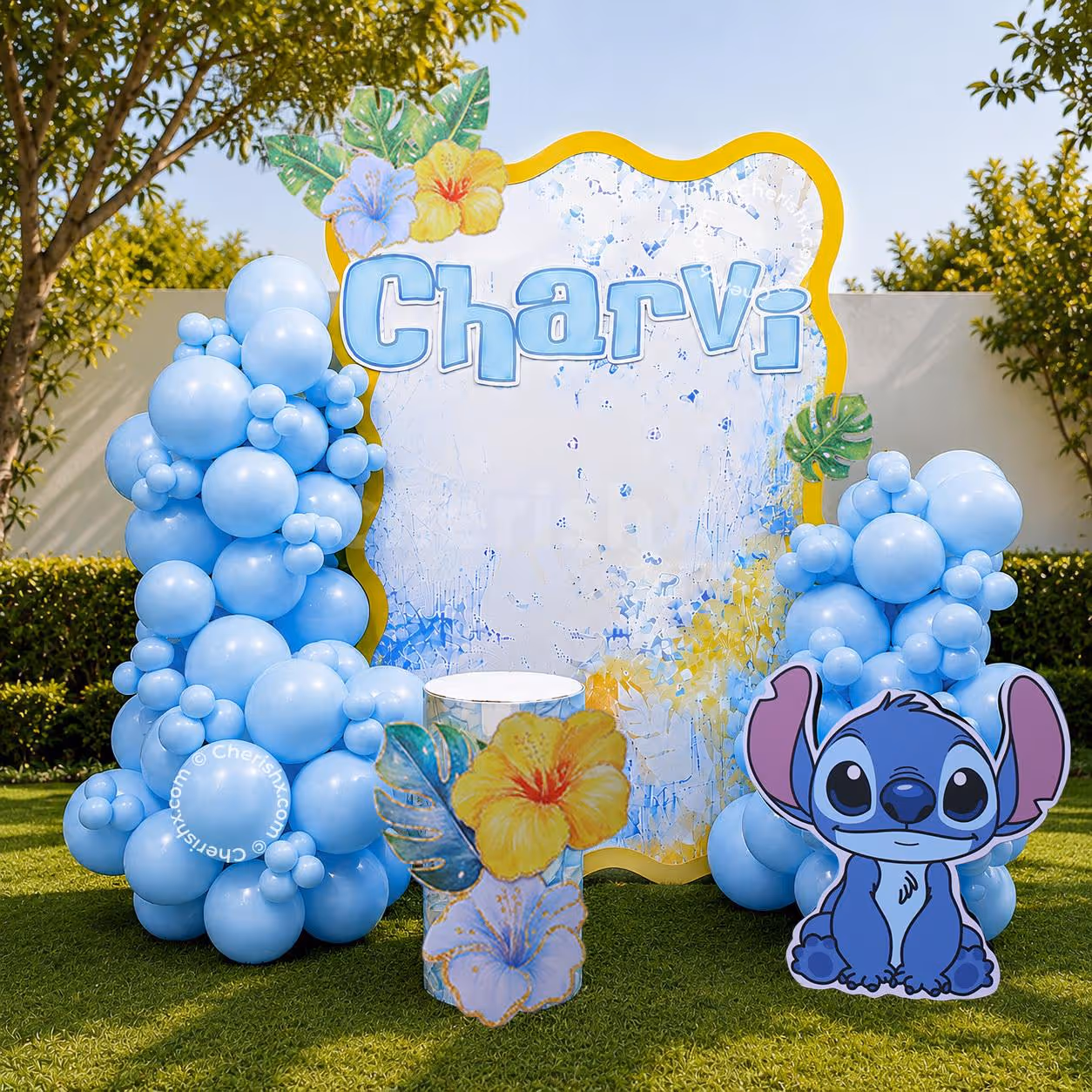 Stitch birthday decor in pastel blue with personalised backdrop, balloon arch and character cutout in a garden setting.