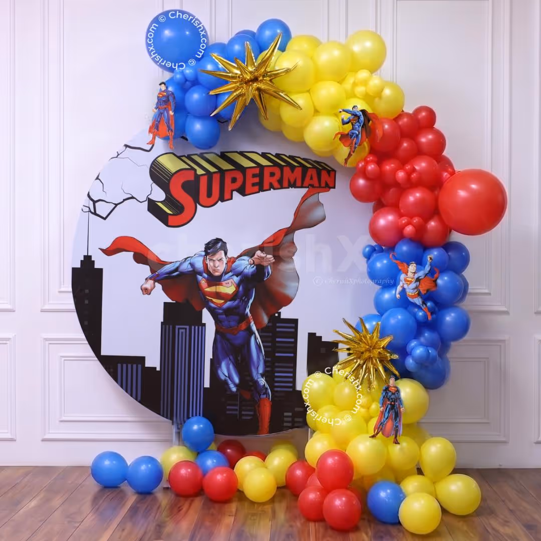 Superman ring stand with red, blue, and yellow balloon garland, 4D star balloons and cutouts.