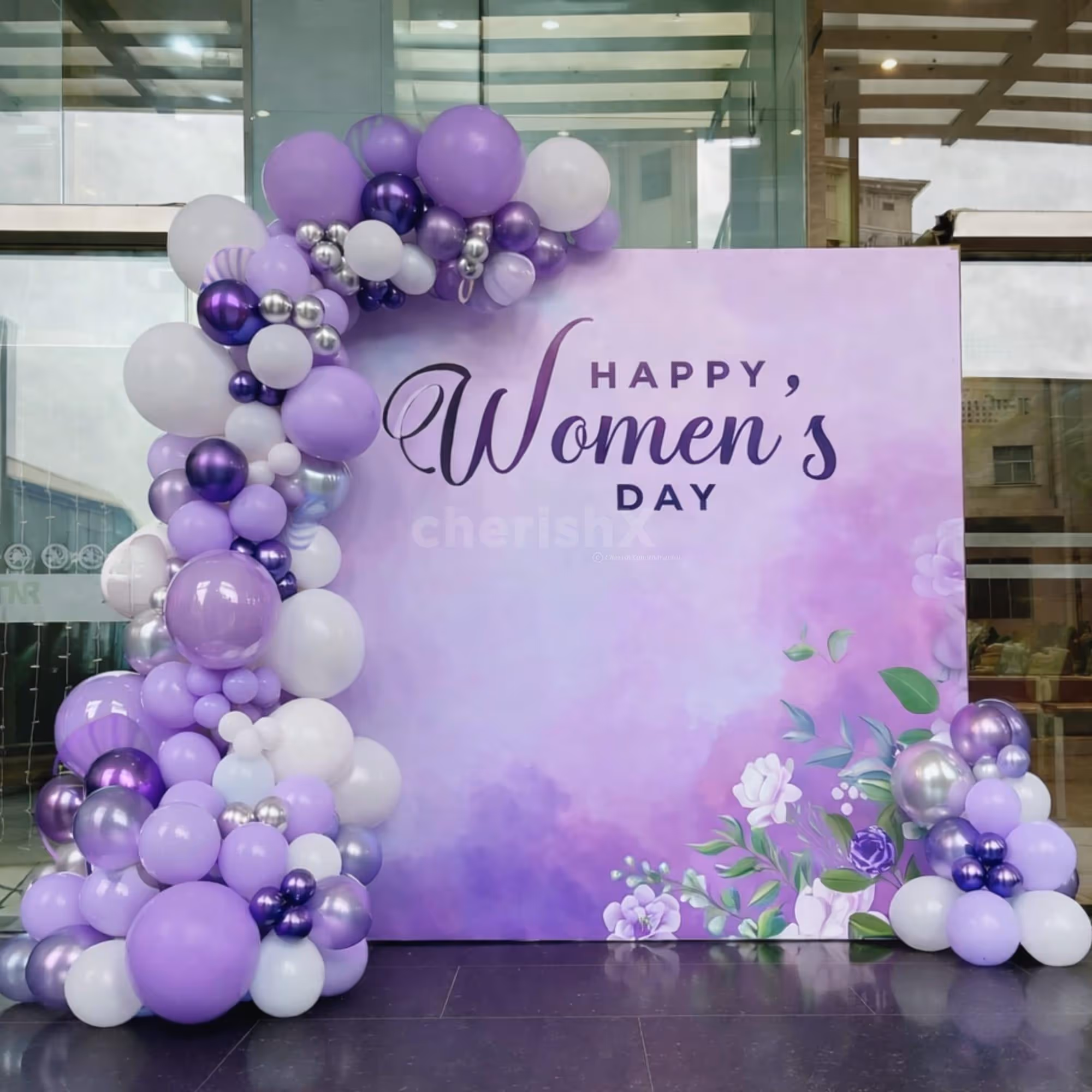 A grand-sized vibrant flex banner on a stand glows with "Happy Women's Day" Signage
