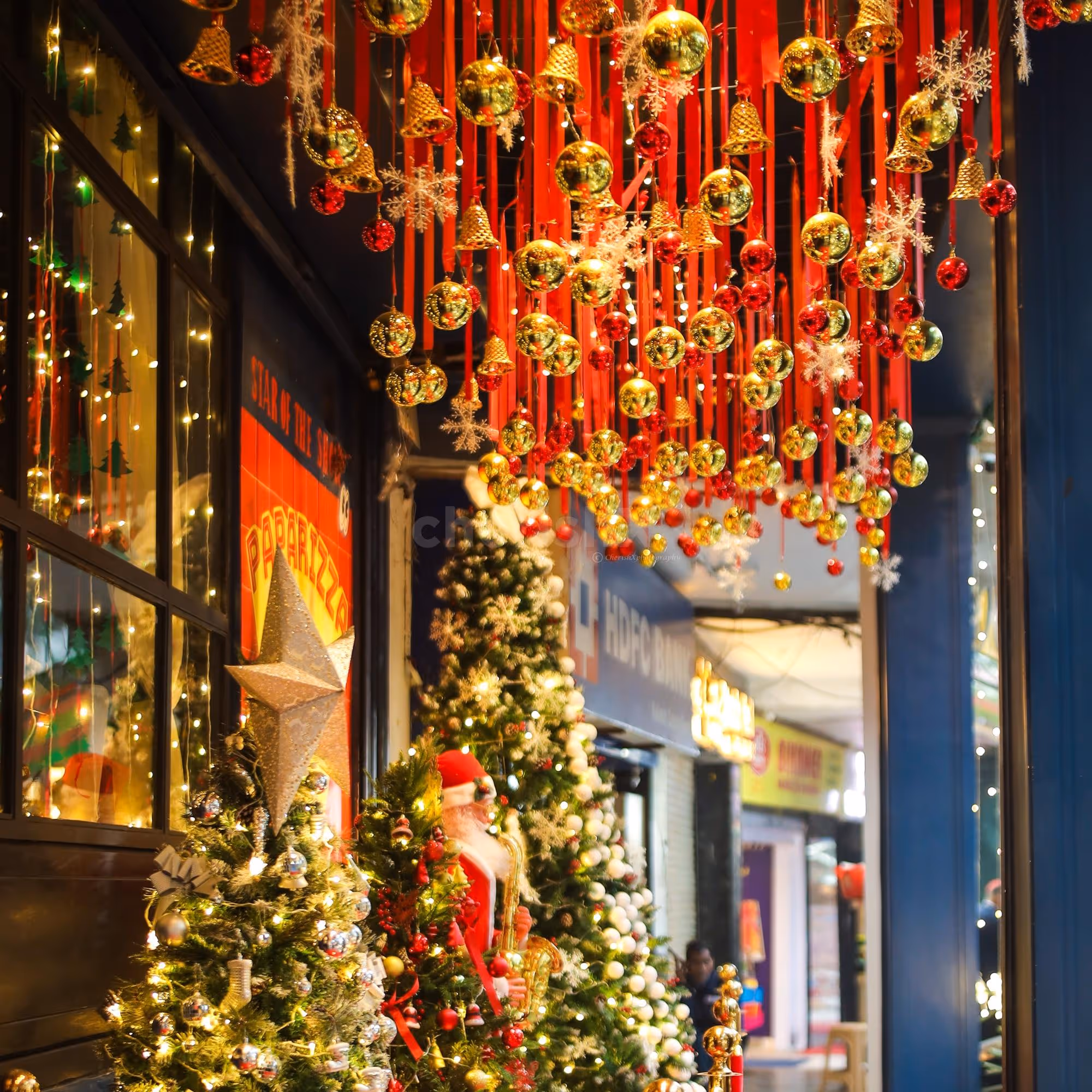Ceiling lighting, golden ball and bells with red ribbons enhance the glamour of the ceiling
